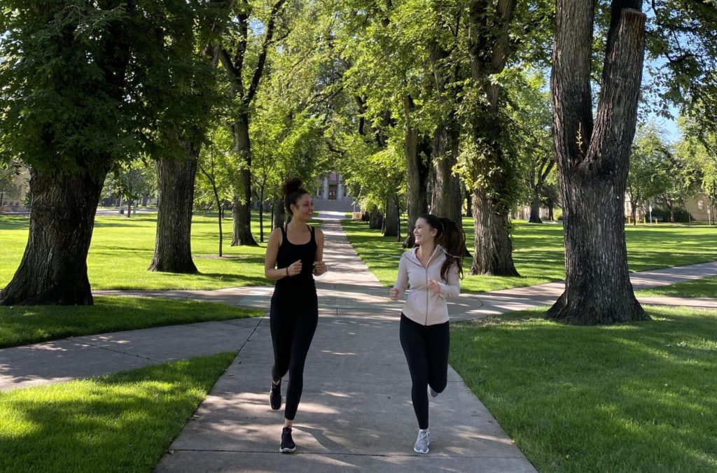 Two people running through the CSU Oval