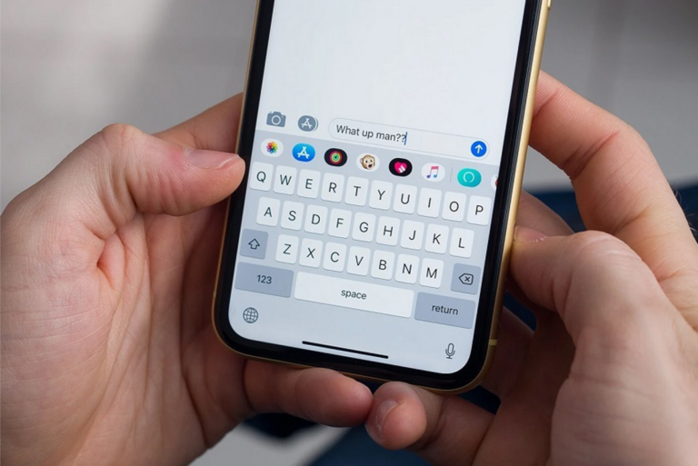 Person typing a message on a smartphone with a visible keyboard and screen.